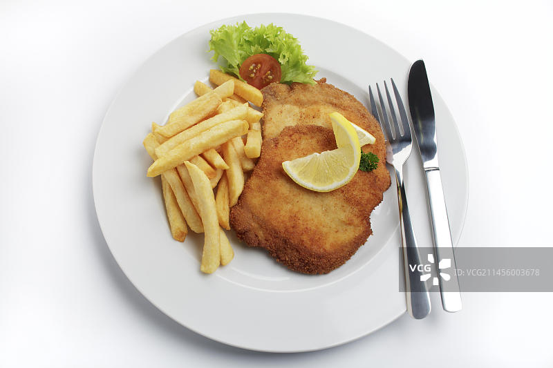 维也纳式面包屑炸猪排配柠檬片和炸薯条图片素材