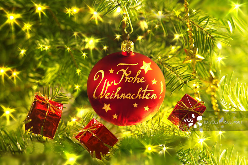 带有“圣诞快乐”字样和小礼品包装的红色圣诞球图片素材