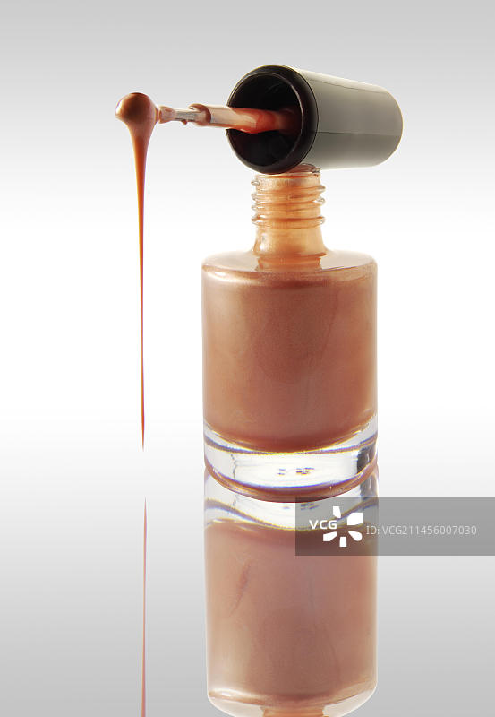 粉色指甲油从指甲油刷上滴落到指甲油瓶上图片素材