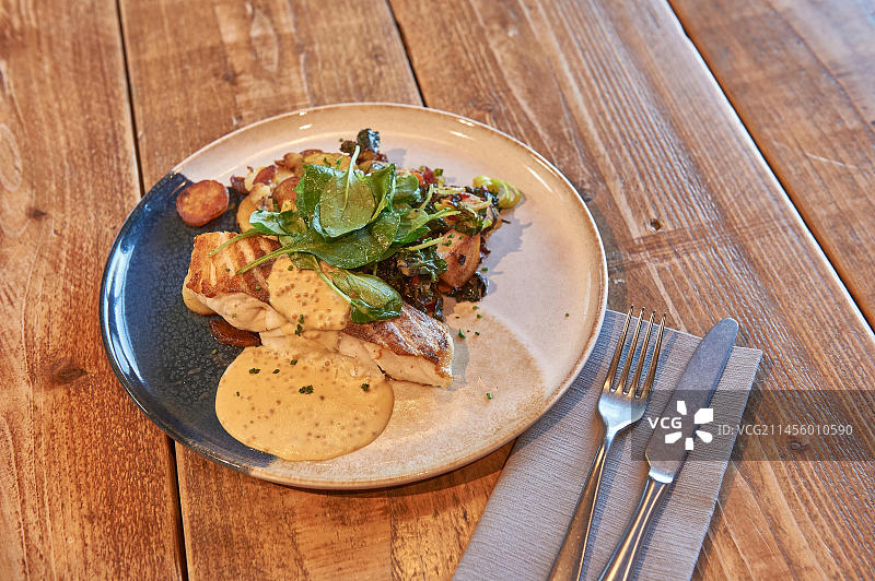 木桌上摆放的鱼肉菜肴图片素材