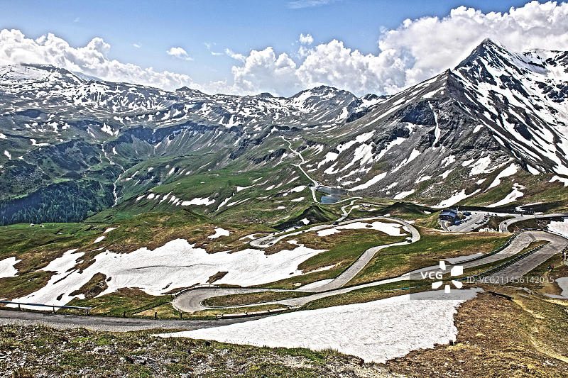 大格洛克纳山高山公路的动态饱和度降低 HDR 拍摄,背景是树线以上的高山湖泊 Fuscher Lacke 以及通往 Hochtor 隧道的车道,位于奥地利萨尔茨堡东蒂罗尔的欧洲图片素材
