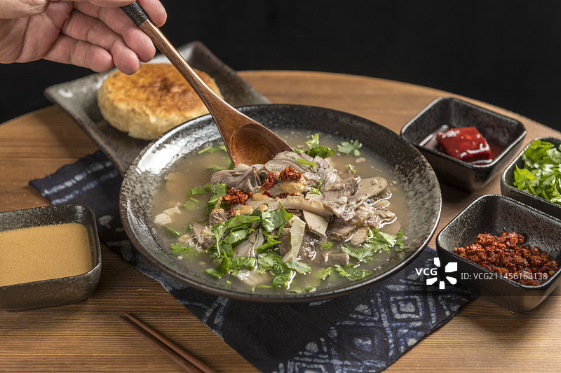 天津小吃全羊汤羊杂汤摆放在木桌面上特写图片素材