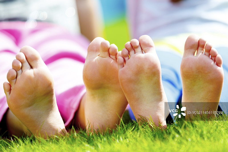 孩子们赤脚坐在草地上图片素材