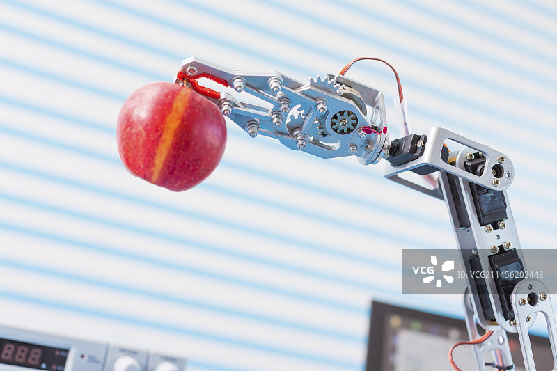 机械臂拿着苹果图片素材