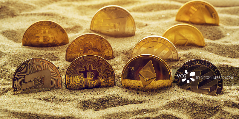 沙子里的加密货币硬币图片素材