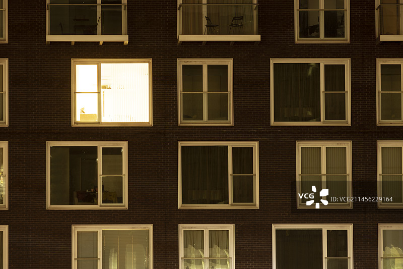 公寓楼里点亮的单扇窗户图片素材