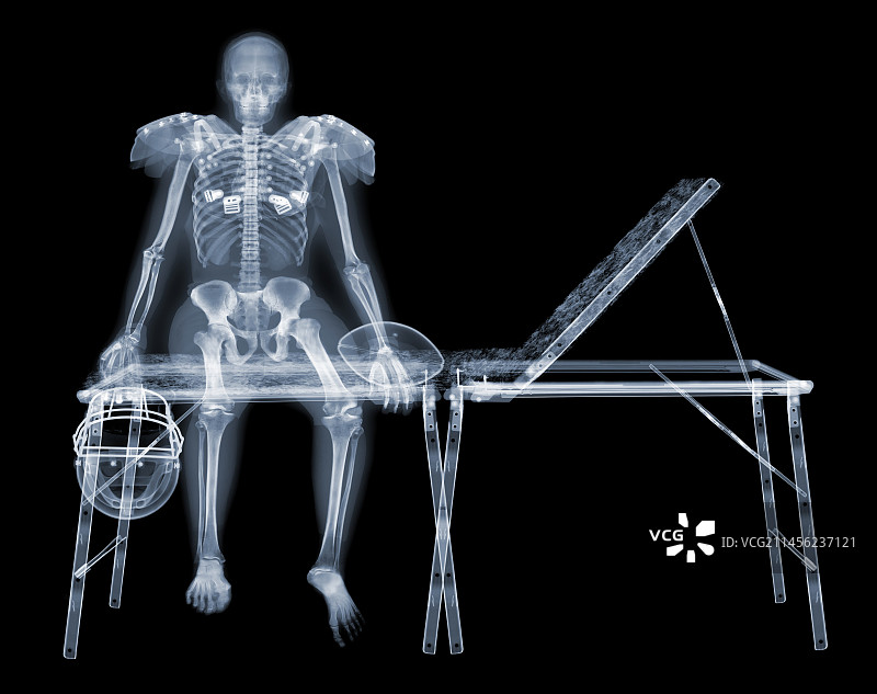 运动沙发上的美式足球运动员的骨骼X光片图片素材