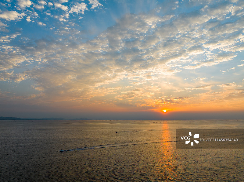 小石岛优美日落橘红色的彩云及返航的船儿图片素材