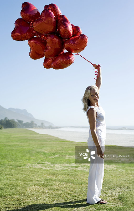女人手拿心形气球图片素材