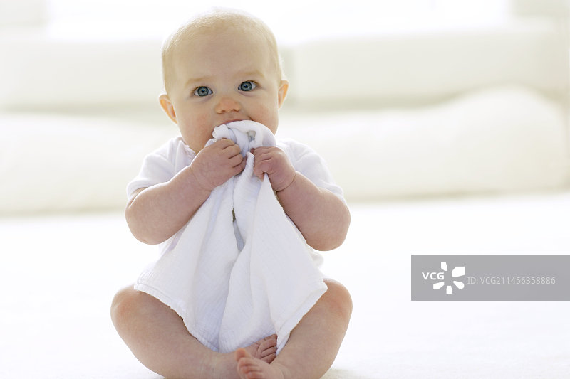 婴儿咬着毯子图片素材