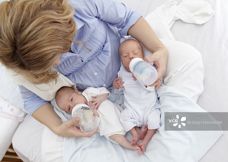 母亲喂养两周大的双胞胎图片素材