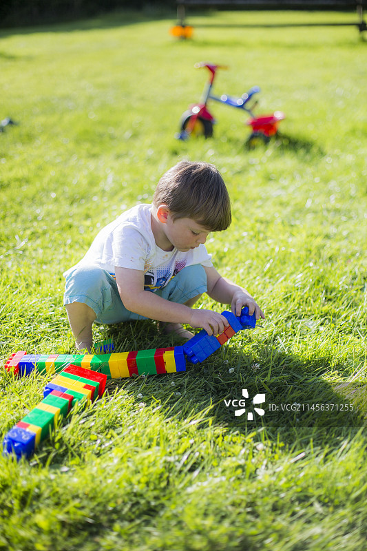 男孩玩塑料积木图片素材