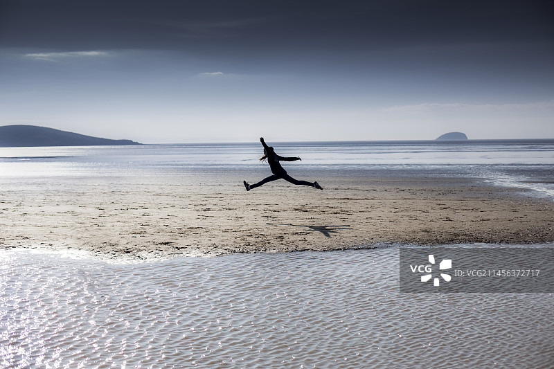 在海滩上跳跃的人图片素材