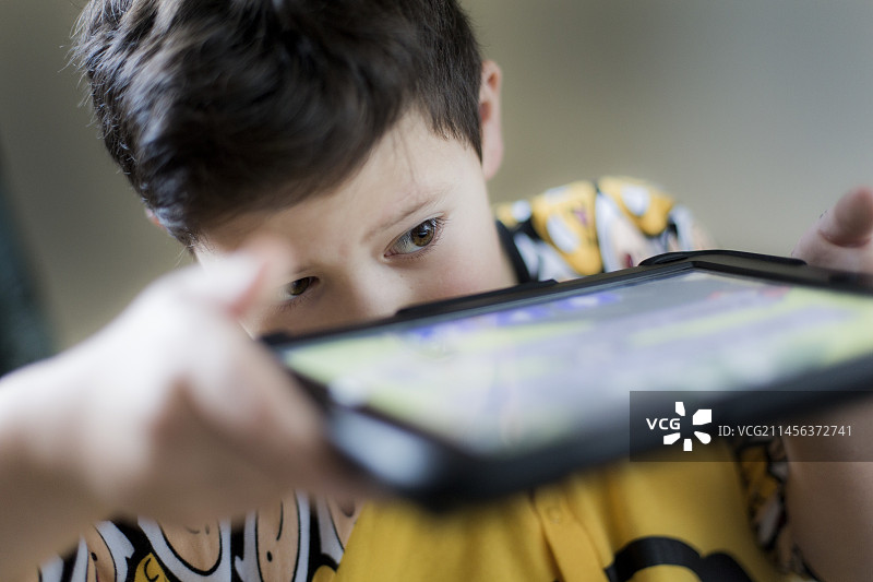 玩掌上设备的男孩图片素材