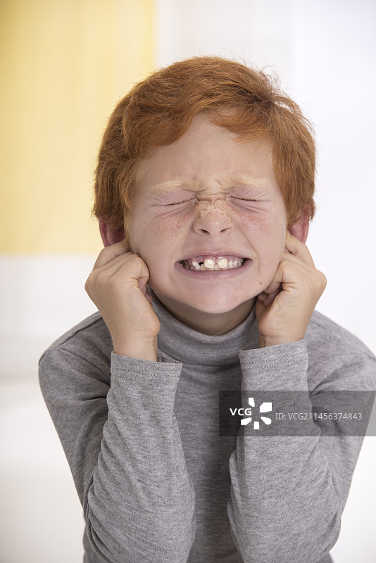 用手指堵住耳朵的男孩图片素材