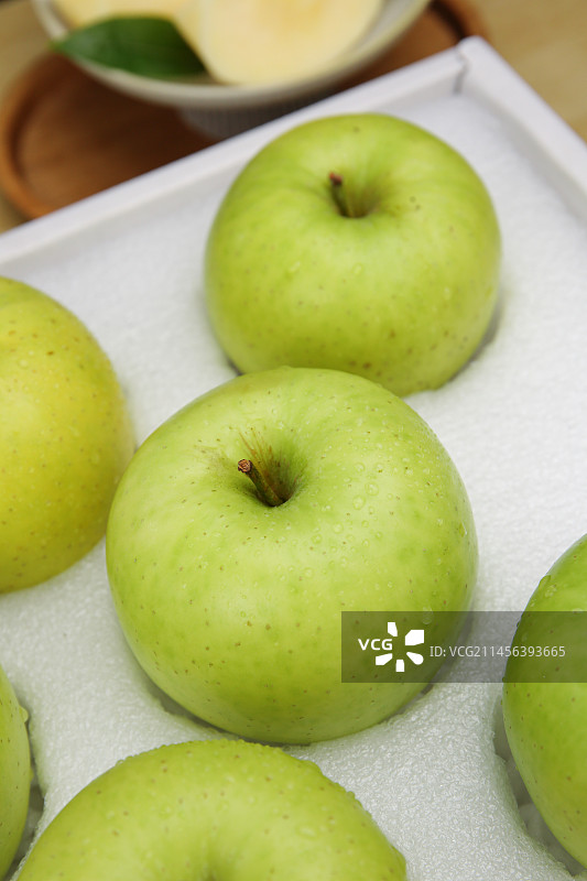 浅底上的一盒青苹果图片素材