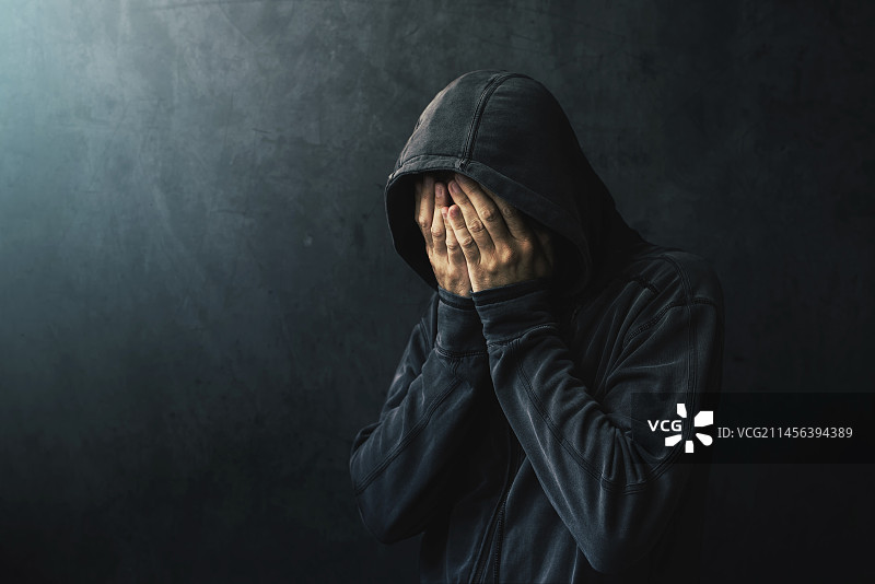 戴帽衫的男人在哭泣图片素材