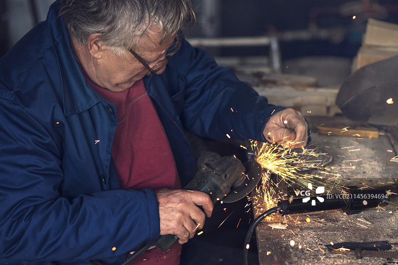 男人使用金属研磨机图片素材
