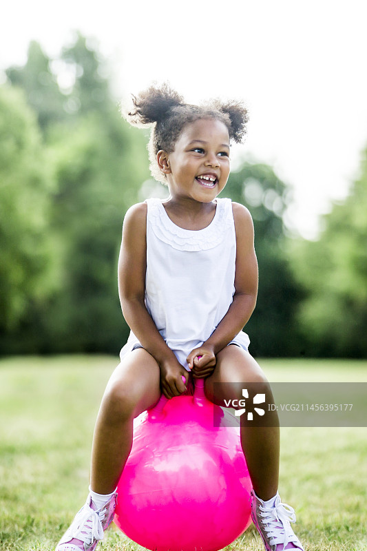 女孩在充气跳跳球上玩耍图片素材
