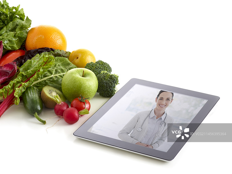 医生在平板电脑上展示水果蔬菜图片素材