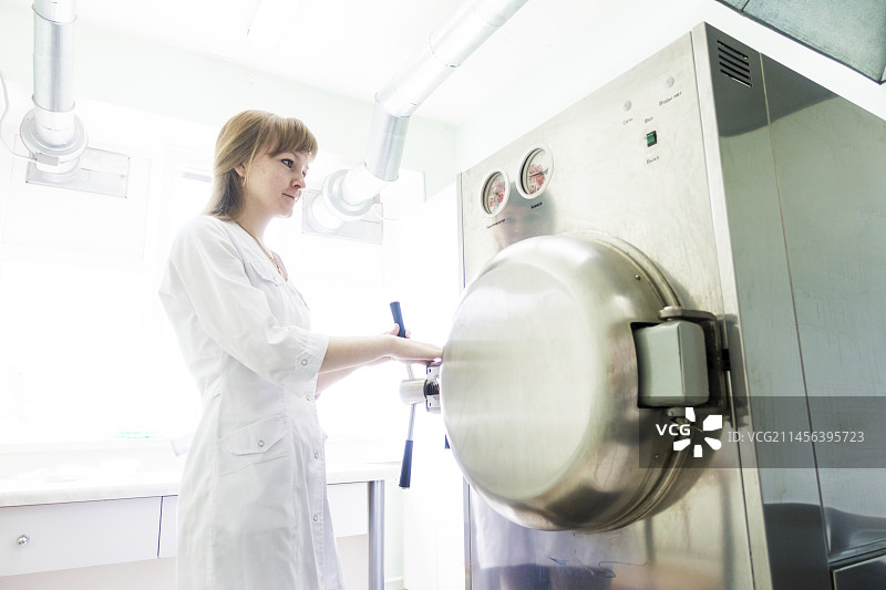 正在操作高压灭菌器的技师图片素材