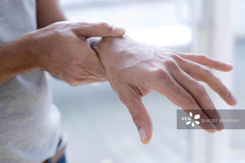 男人痛苦地触摸手腕图片素材