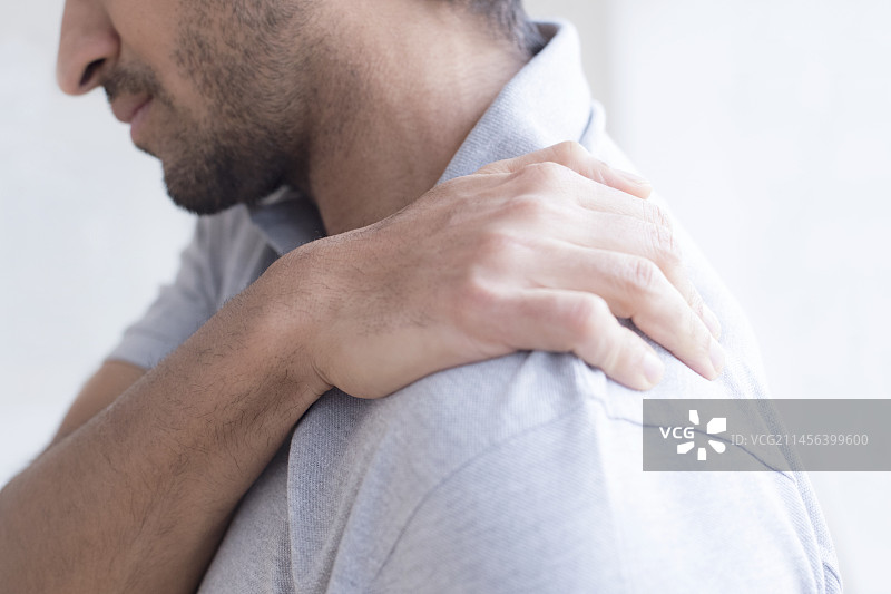 男子痛苦地触摸肩膀图片素材