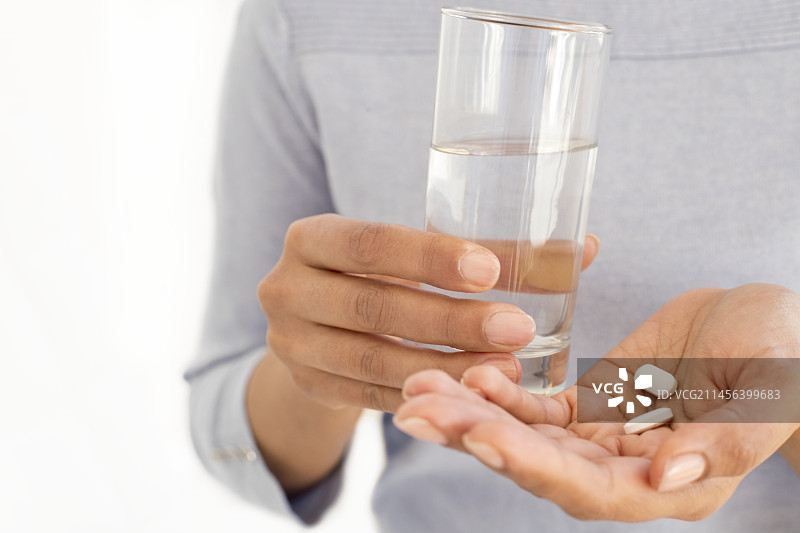 女人拿着药片和水图片素材