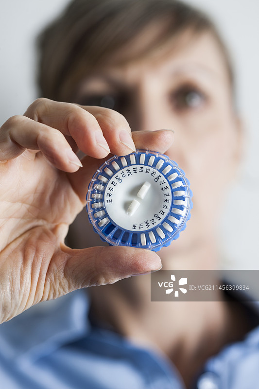 女人拿着激素替代疗法药丸图片素材