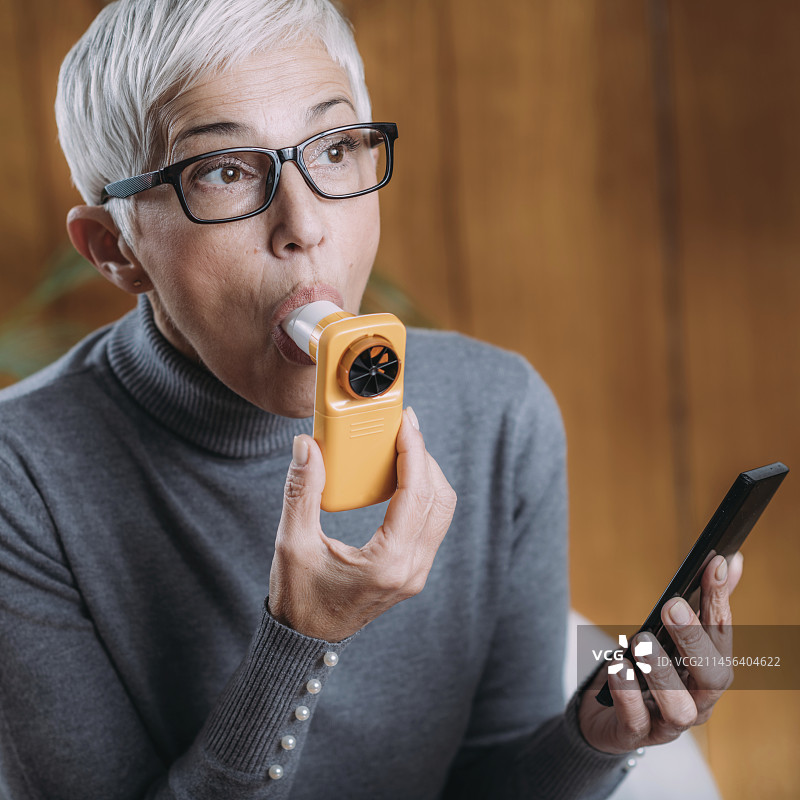 使用带智能手机应用程序的数字肺活量计进行肺活量测定图片素材