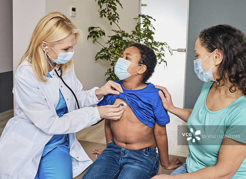 医生正在听男孩的胸部图片素材