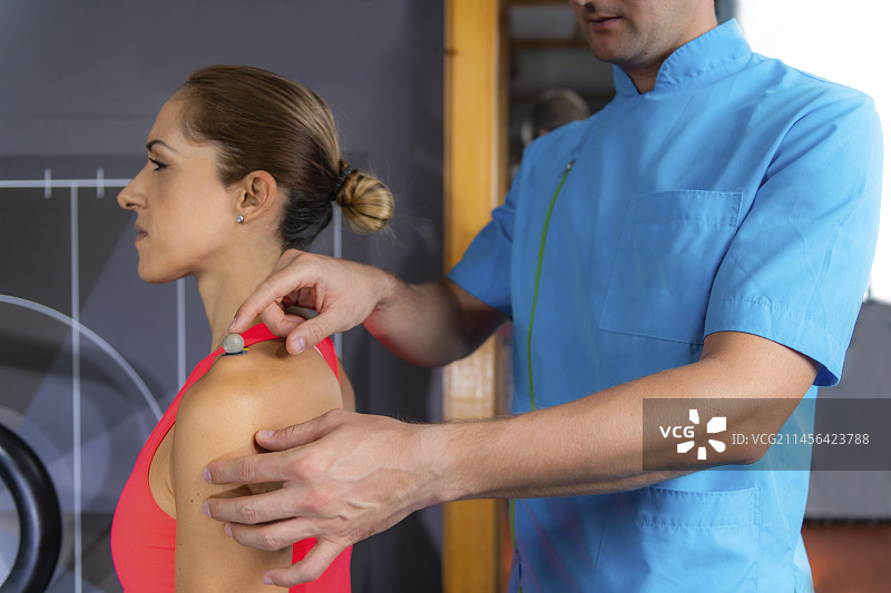 技术员在运动员的肩膀上放置标记图片素材