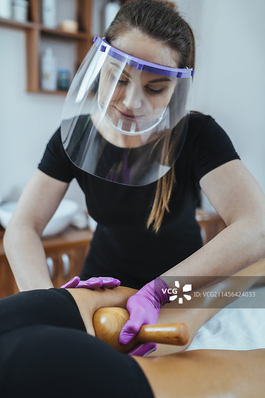 佩戴个人防护装备的马德罗按摩理疗师图片素材