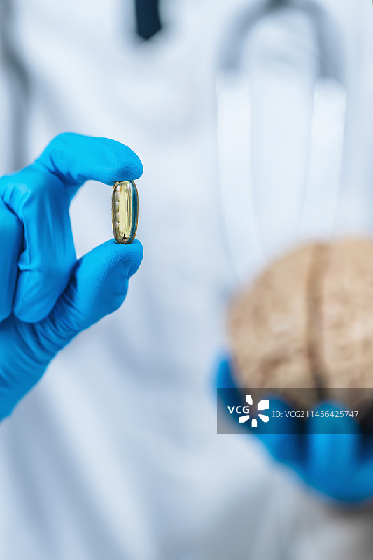 女医生手持大脑模型和安慰剂药丸图片素材