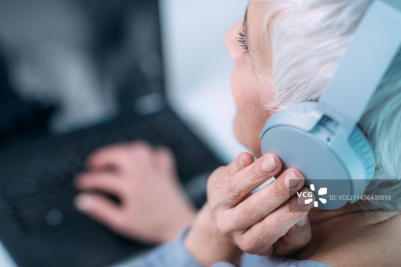 女人使用笔记本电脑和耳机图片素材