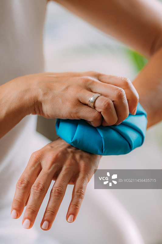 女人用冰袋冷敷疼痛的手腕图片素材