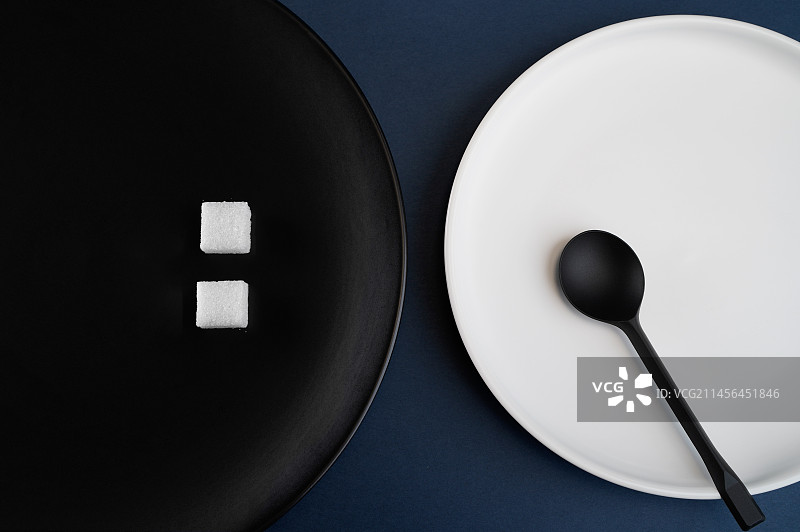 黑白色盘子中的方糖和勺子简约静物照图片素材
