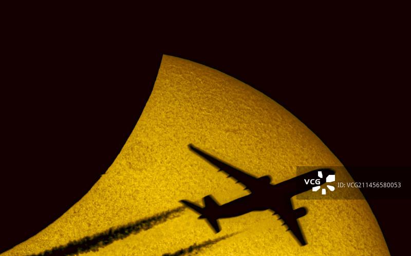 日偏食期间以太阳为背景的飞机剪影图片素材