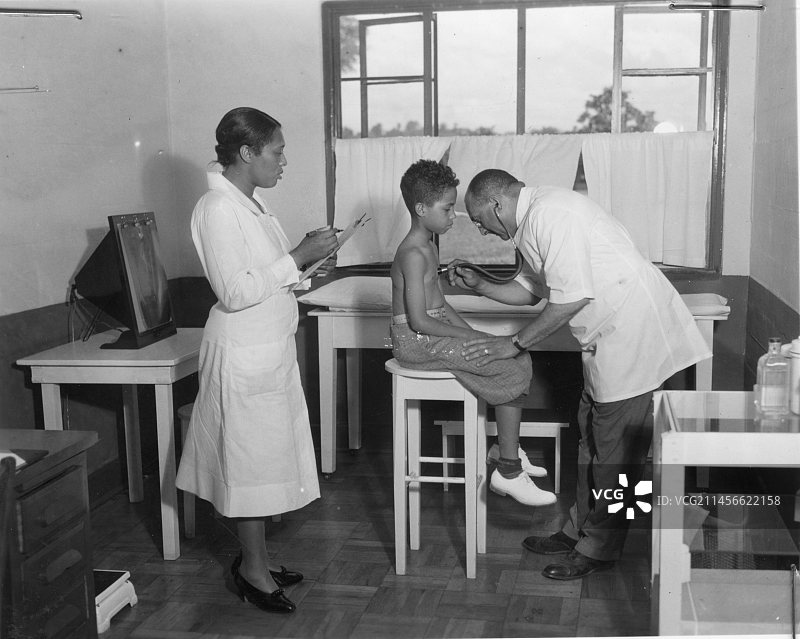 医生在卫生中心为男孩检查肺结核图片素材