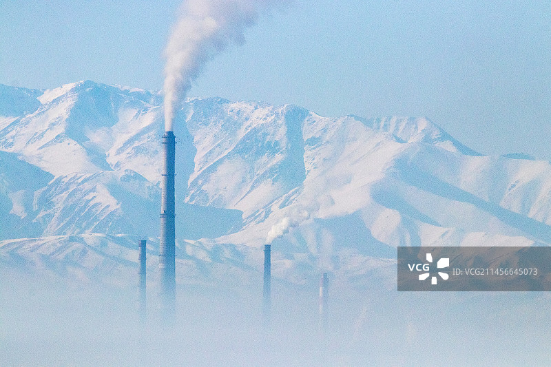 吉尔吉斯斯坦比什凯克烟雾与烟囱污染，背景是山脉图片素材