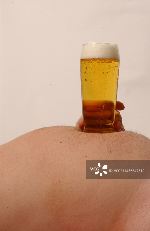 男人将啤酒杯放在肚子上图片素材