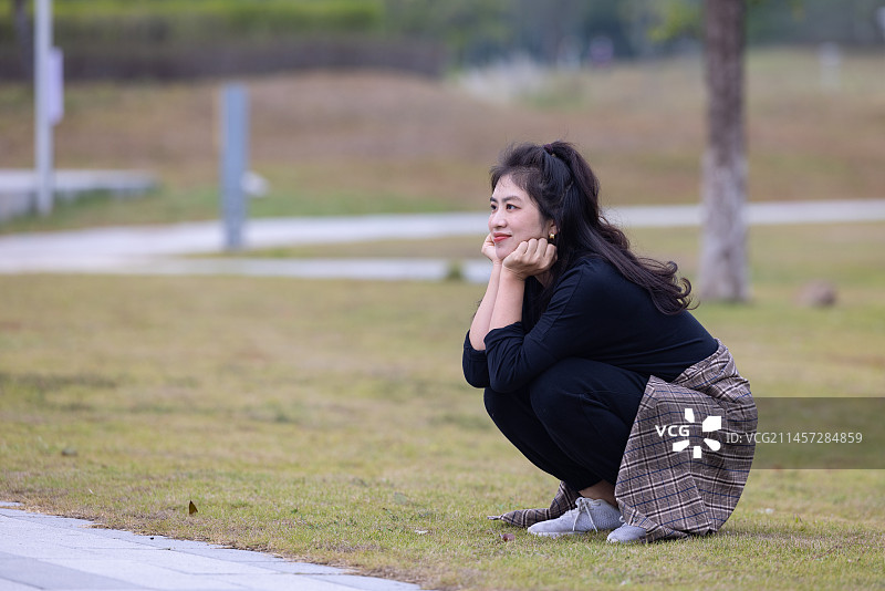 坐在草地上的年轻女子图片素材