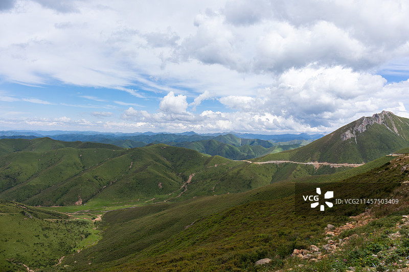 甘肃甘南甘南藏族自治区江迭公路沿途风景蓝天白云下覆盖着绿色植被的连绵的高山图片素材