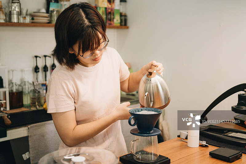 年轻女子在泰国清迈的咖啡馆担任咖啡师图片素材
