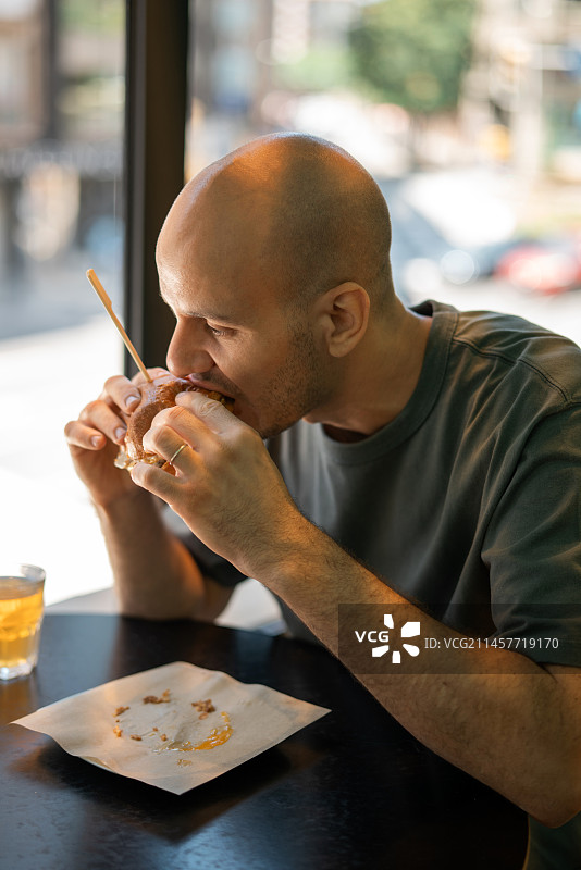 男人在餐厅吃汉堡喝啤酒的肖像图片素材