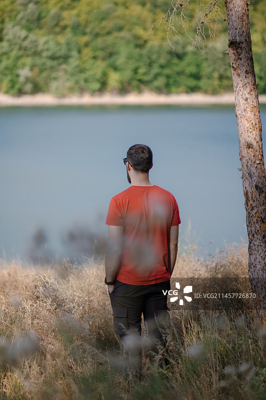 男子站在湖边原野上的背影图片素材