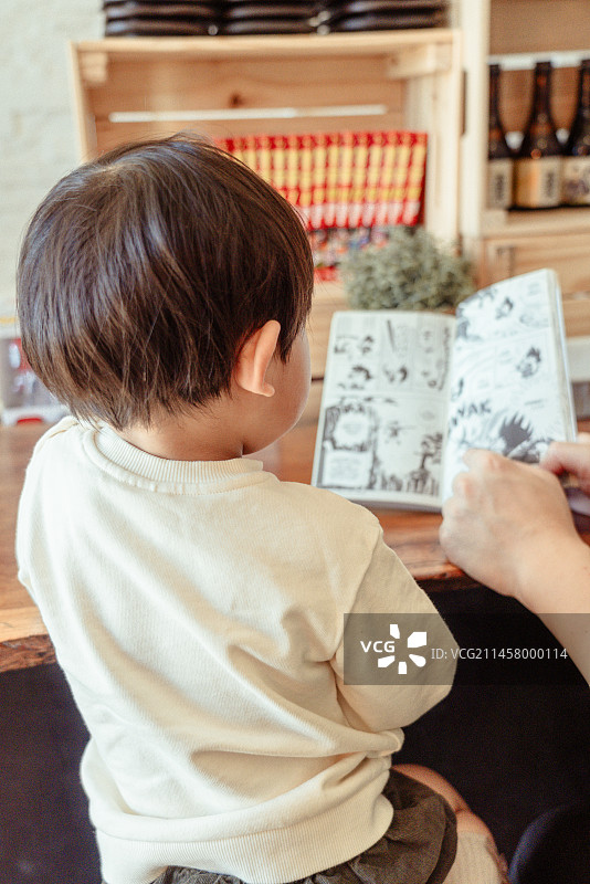 爸爸陪同小孩看漫画书图片素材