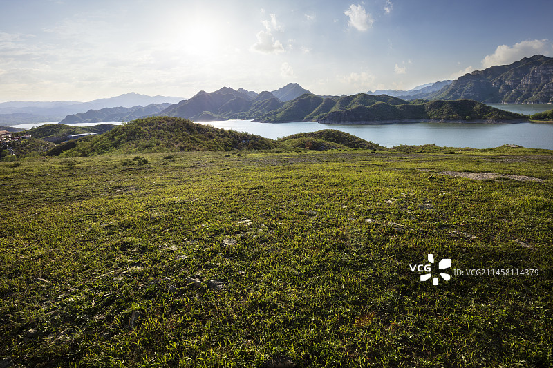在山顶草地平台上远眺群山湖泊图片素材