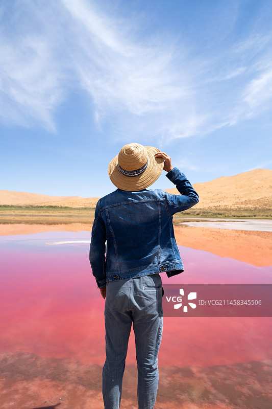 男性游客在中国西部内蒙古阿拉善右旗巴丹吉林沙漠粉红湖的旅拍写真图片素材