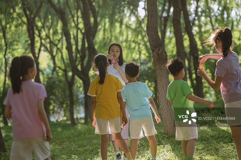 小学生和老师在公园做游戏图片素材